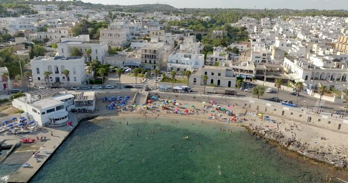 Aerial view of the city beach in the center of Santa Maria di Leuca in Salento, Puglia, Italy. It is a small sandy beach with tourists bathing.