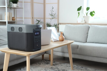 Portable power station with laptop on table in living room