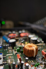 A closeup of a printed Circuit Board showing an Inductor and various electronic components