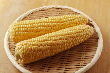 ざるにのった調理前のトウモロコシ
