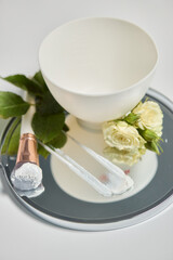 An Elegant Spa Setup Featuring a Beautiful Bowl, Fresh Flowers, and Essential Skincare Tools