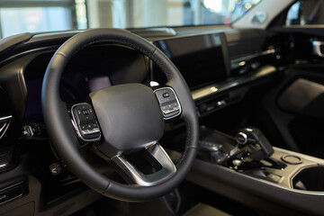 Closeup of a modern car steering wheel with control buttons for technology and convenience