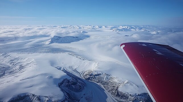 Aerial View of Snowy Mountains and Clouds from a Small Plane
