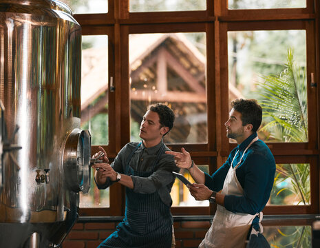 Worker, tablet and examine tank in brewery for machine inspection, quality assurance and production management. Team, people and digital app in small business for checking beer manufacturing system - Powered by Adobe