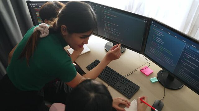 Slow motion back end software developer engineer for computer programming working together on debugging writing computing code, solving complex algorithms display on monitor in office. Burgeoning