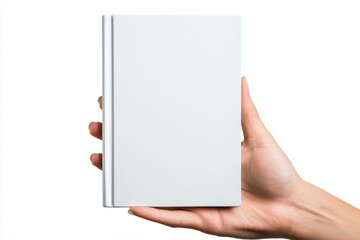 A person is holding a white book in their hand