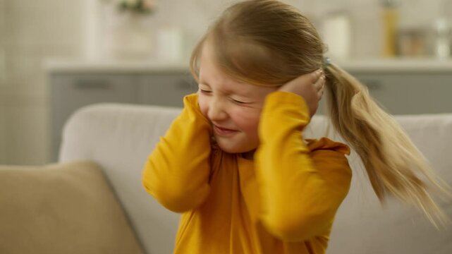 Little girl child cover ears hands daughter offspring problem childish displeased unhappy crazy preteen character bad parenting teach hyperactivity naughty kid learner schoolgirl hysteria protest home
