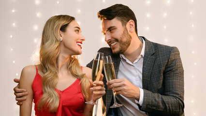 Young Couple Having Romantic Evening In Restaurant, Clinking Glasses With Champagne, Making Toast For Valentine's Day