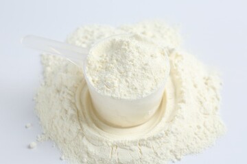 Protein powder and scoop on white background, closeup