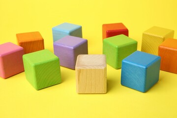 Fototapeta premium Many wooden colorful cubes on yellow background