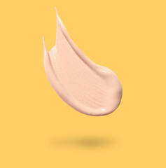 Skin foundation in air on golden background. Cosmetic product