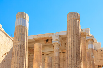The pillars are made of stone and are very tall, the Acropolis of Athens