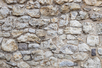 Full frame abstract texture background of a rustic gray medieval stone wall
