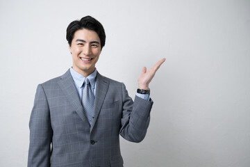 オススメポーズをする若いビジネスマン　白背景