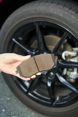 【自動車メンテナンス】ブレーキパッドを持つ女性の手