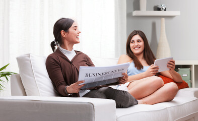 Mother and daughter sharing quality time reading relaxing on sof