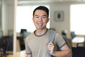 A young student with a backpack is smiling at the camera