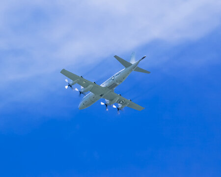 US Navy P-3 Orion Submarine Chase Plane flying across deep blue sky