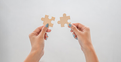 Closeup hand of woman connecting jigsaw puzzle, Business and strategy success concept.
