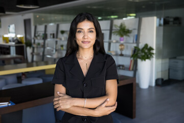 Confident beautiful middle Eastern business leader woman posing for portrait in modern co-working,...