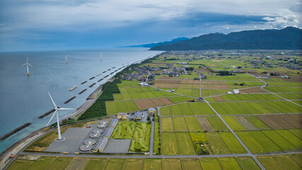 Offshore wind turbines, breakwaters, windbreak forests, etc. on the coastline facing Toyama Bay in Japan © 済 君島