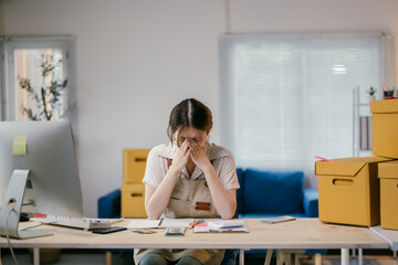Stressed asian woman managing business from home, overwhelmed by bills and paperwork, looking tired...