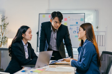 Business executives discussing over new business project in meeting. Young asian business people analyzing data using laptop computer and digital tablet