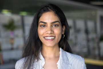 Happy beautiful Indian manager girl head shot video conference screen portrait. Positive young...