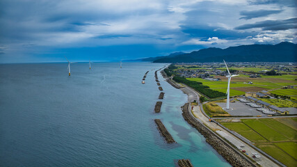 Offshore wind turbines, breakwaters, windbreak forests, etc. on the coastline facing Toyama Bay in Japan © 済 君島