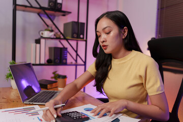 Fototapeta premium Asian woman sitting at work, busy with documents, stressed face, busy with work.