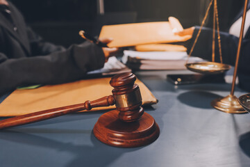 Obraz premium Judge gavel with Justice lawyers having team meeting at law firm background. Concepts of Law and Legal services.
