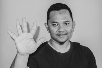 A man is raising his index finger to count five