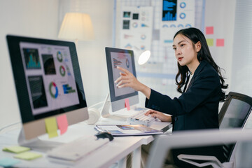 Young professional is reviewing data visualizations on her computer, engaged in a focused analysis...
