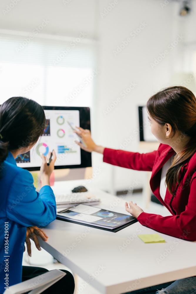 Poster two businesswomen discussing financial data on a computer, strategizing for the future with teamwork
