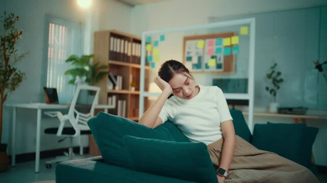 Young woman browses her smartphone, growing increasingly bored and tired. Eventually, she puts her phone down, reflecting feelings of frustration and disinterest