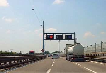 fuel tanker is speeding down the highway and passes under a speed detection portal that measures its velocity