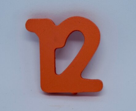 close up photo of a children's toy in the shape of the number twelve, made of wood and orange paint