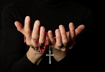 praying to god with hands together with crucifix cross on black background with people stock photo...