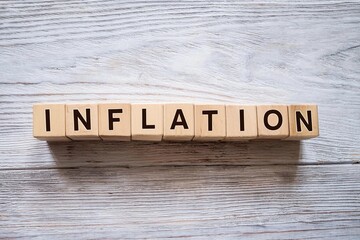 the word INFLATION written on small wooden blocks on white wooden background. Economy and financial concept 
