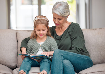 Book, relax or storytelling with girl and grandmother on sofa in living room of home for bonding or...