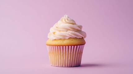 Single vanilla cupcake with white frosting against a pink background.
