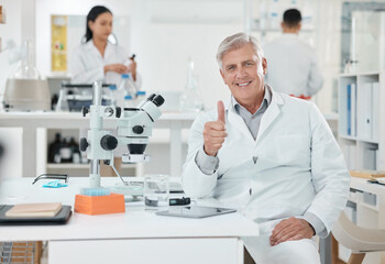 Laboratory, thumbs up and portrait of mature man with confidence, smile and medical science. Healthcare, happy and scientist at office desk with agreement, like or study in pharmaceutical engineering