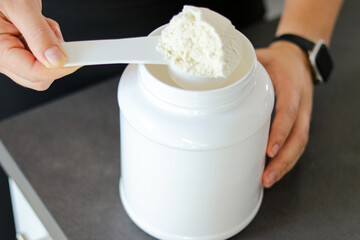Close up of woman preparing a protein shake in the kitchen. Diet meal replacement for weight loss 
