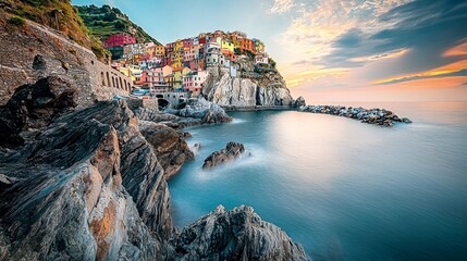 Fototapeta premium A picturesque Italian coastal town with colorful buildings perched on a cliff overlooking the sea at sunset.