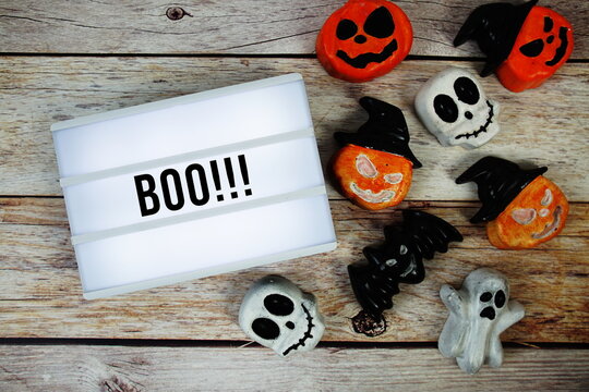 Halloween Concept with Boo!!! text in lightbox and Halloween Element decoration on wooden background