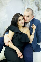 A young couple in a room decorated for Christmas or New Year.