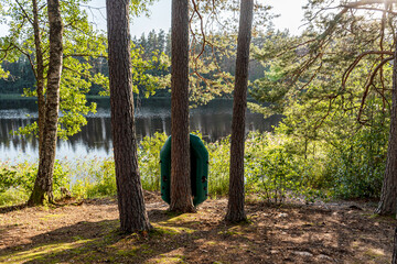 beautiful summer landscape with a lake, green rubber boat on the shore of the lake, wild aquatic...