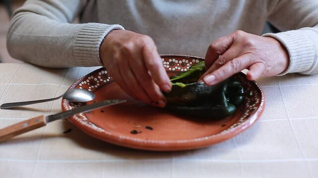Woman cleans inside of poblano chili