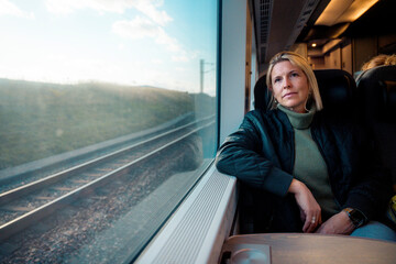 Female Traveler Looking Out Train Window in Scandinavia