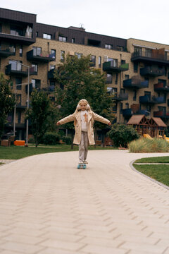 Happy girl pushing off on skateboard on street